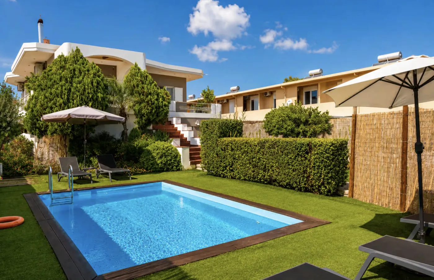 Private pool with artificial lawn and sun loungers at Villa Morea