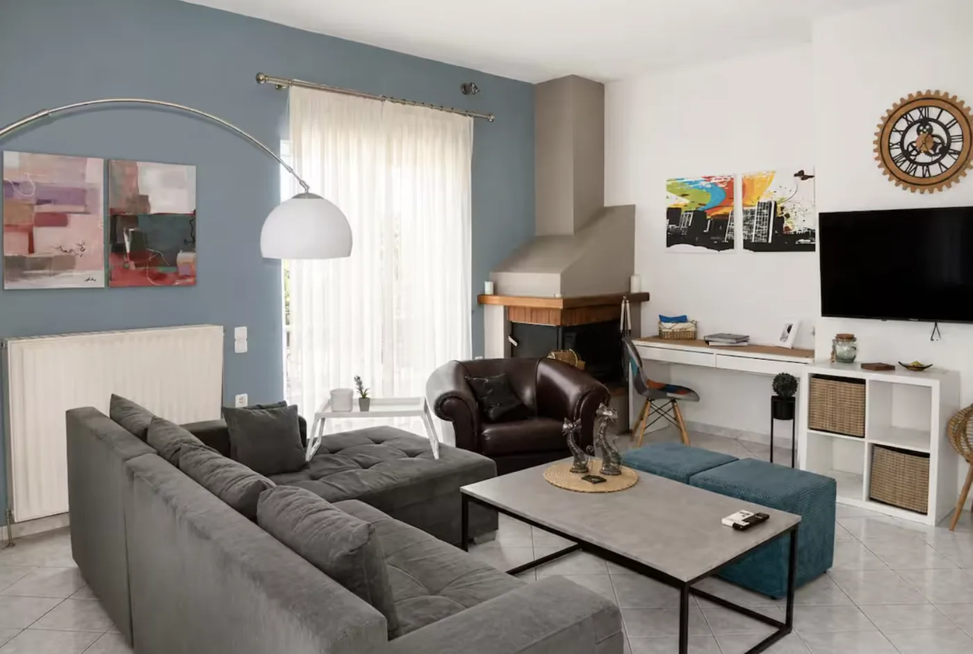 Living room with grey corner sofa bed, fireplace and TV at Villa Morea